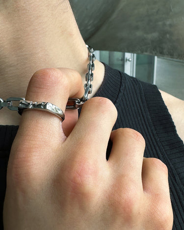 On finger view of our rebirth logo silver ring in silver optic. Stainless steel ring with the bms logo and waterproof
