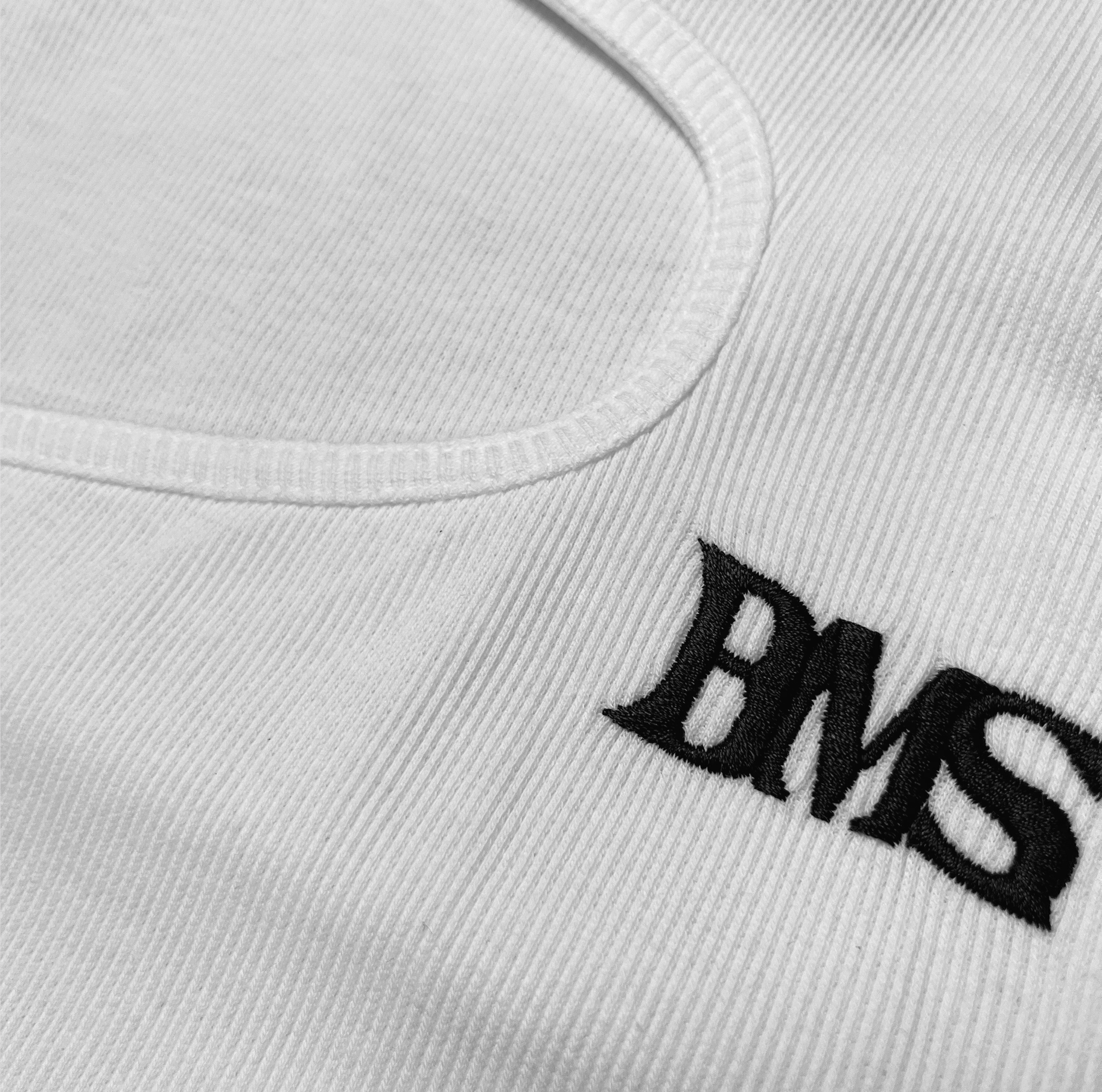 Detail view of our cut out ribbed top in color white with black logo embroidery summer top 
