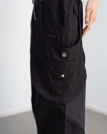 Detail side view of our survivor unisex baggy pants / jeans in black color with silver elements and detachable sidepocket 
