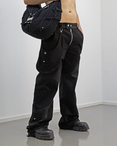 Full outfit view of our survivor unisex baggy pants / jeans in black color with silver elements and detachable sidepocket 